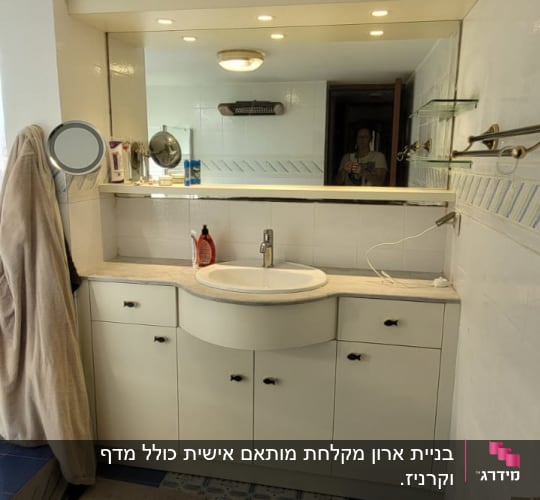 חדר אמבטיה עם ארון כיור ומראה גדולה